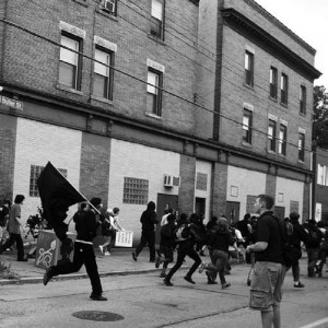 A protester raises a black flag during the Pittsburgh G20