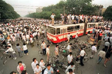 Beijing residents using a bus as a roadblock to stop troops from advancing to Tiananmen Square in June 1989