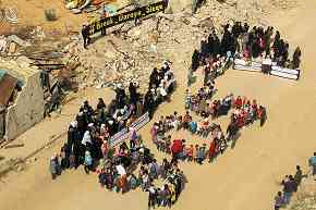 Protest, Daraya, Syria, 2016: people form letters "SOS," sign reads "#Break Daraya Siege" Protest, Daraya, Syria, 2016: people form letters "SOS," sign reads "#Break Daraya Siege"