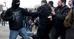 Photo shows a masked antifa counter-protester squaring off against Matthew Heimbach, who takes a defensive position.