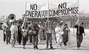 Photo shows a group of protesters with musical instruments. Banner reads, "No incinerator. No compromise."