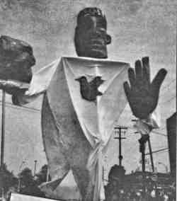 Photo shows a 15-foot tall puppet at a protest demonstration.