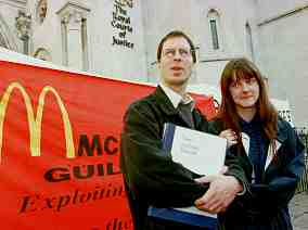 Photo shows two young people standing in front of a banner reading "McDonalds Guilty."