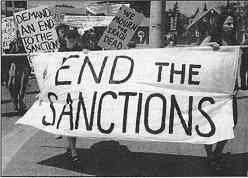 photo shows a group of women protesters with signs and a banner that reads, "End the Sanctions."