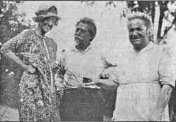 Photo shows three smiling adults; see details in image caption.