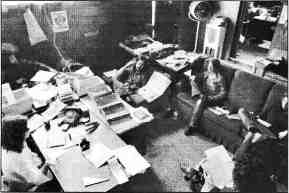 Photo shows 5 or 6 people seated on a couch and chairs in the Fifth Estate office.