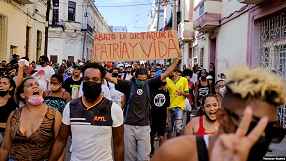 People walk down one of the main streets of Havana, Cuba, chanting anti-government slogans on July 11, 2021.