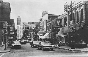 A black-and-white photo shows Detroit's Greektown seen from Monroe and St. Antoine streets.