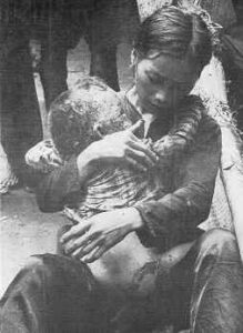 A photo shows a Vietnamese mother caressing her baby, who is gravely injured by U.S. dropped mapalm. Explanatory text appears on the same page.