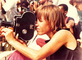 A photo shows a young woman operating a home movie camera, 1960s style.